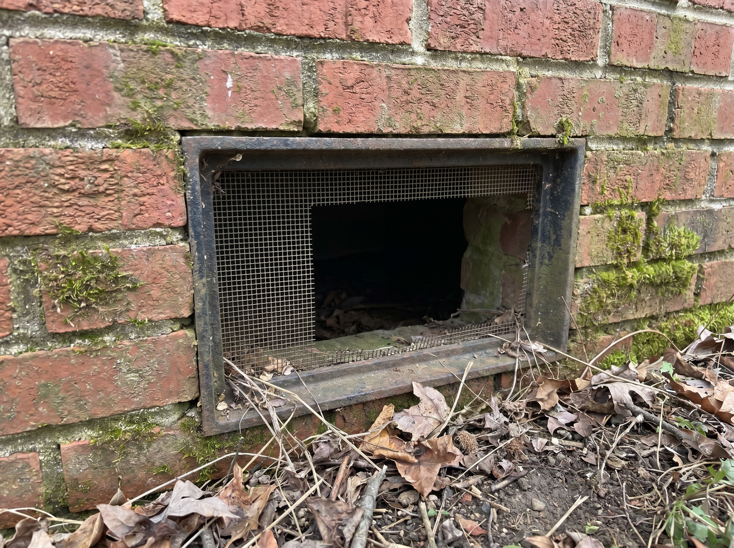 Open foundation vent letting humid Tennessee air into a crawl space